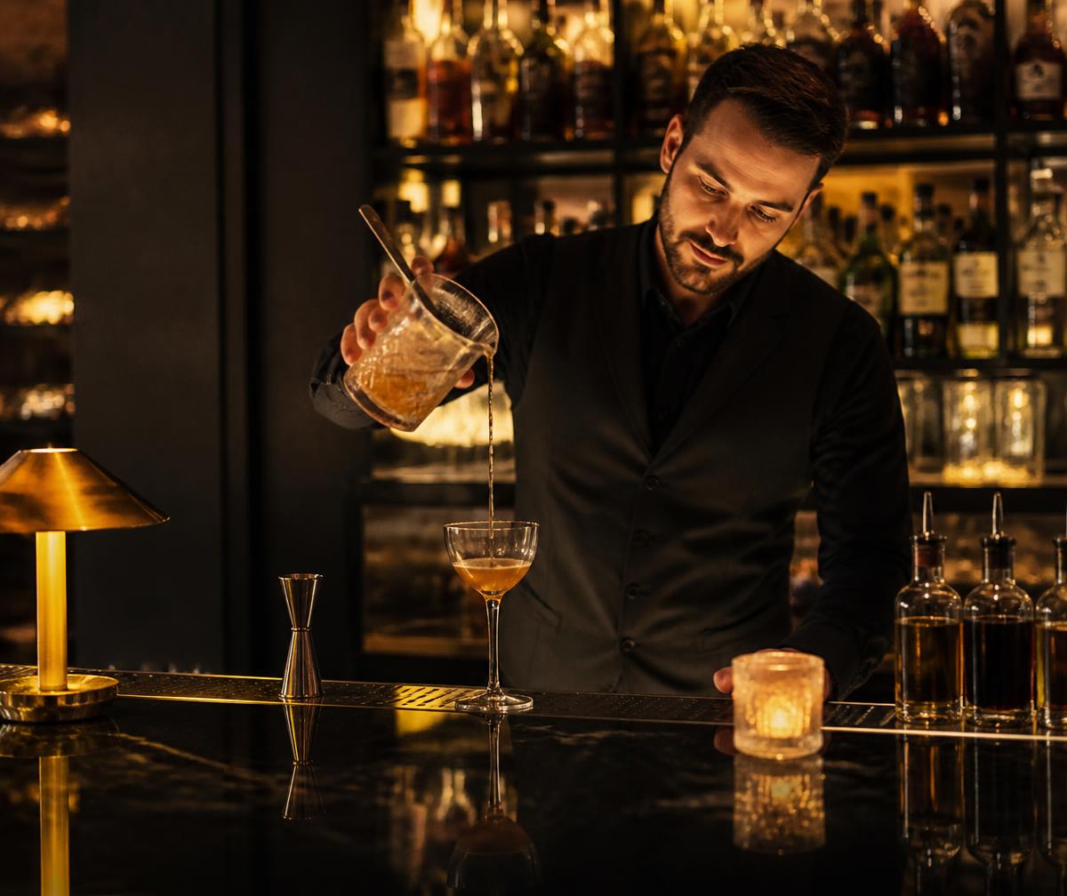 Bartender pouring a cocktail in a moody lounge